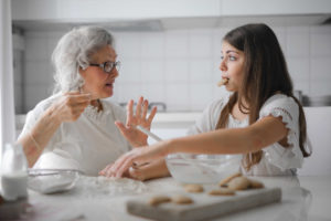 Eldery grandmother cooking with grandchild